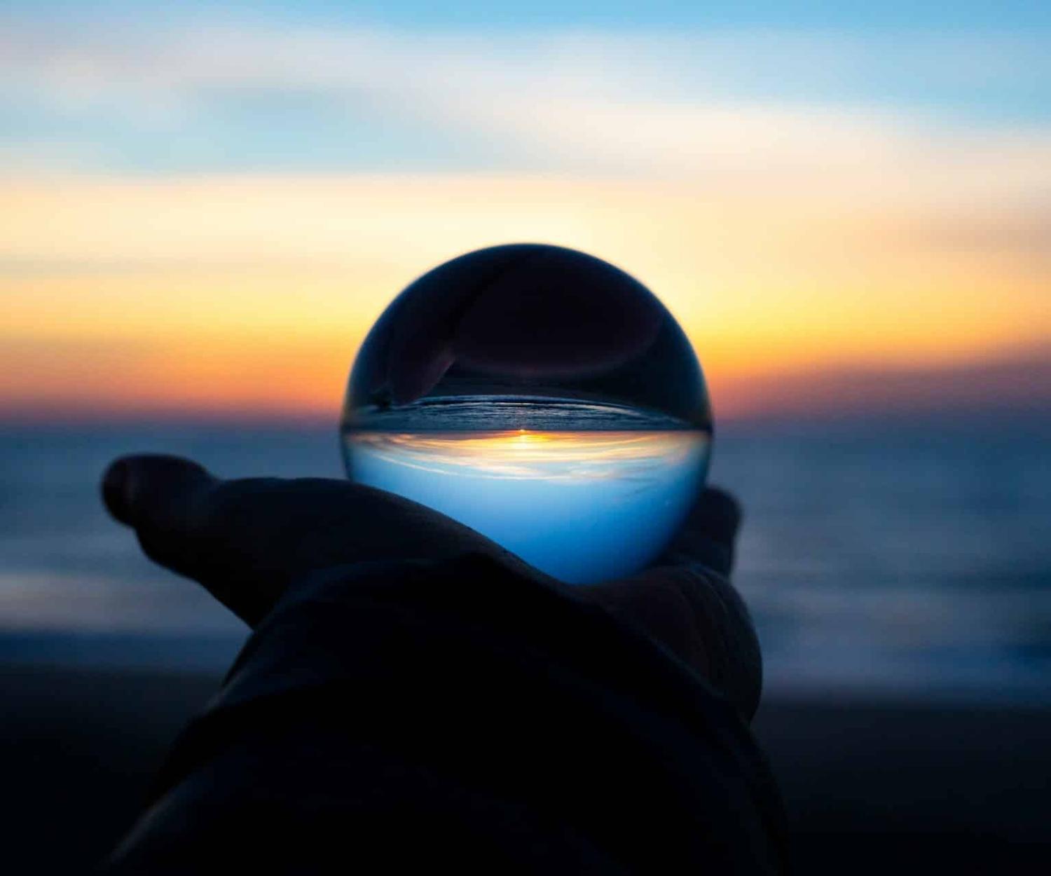 Boule en verre devant un coucher de soleil